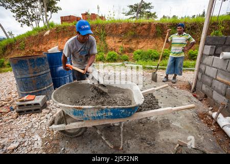 Due uomini stanno mescolando cemento, sabbia e acqua in una buona miscela concreta da utilizzare per costruire una casa nella provincia di Cocle, Repubblica di Panama. Foto Stock