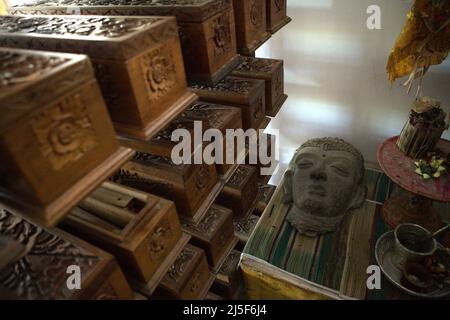 Una scultura, un insieme di attrezzature balinesi e scatole di legno contenenti vecchi manoscritti balinesi a foglie di palma presso il museo Gedong Kirtya a Singaraja, Buleleng, Bali, Indonesia. "L'accesso al contenuto dei manoscritti è limitato, a causa delle difficoltà linguistiche e della fragilità del documento", ha scritto un team di scienziati guidati da Made Windu Antara Kesiman di Laboratoire Informatique Image Interaction (L3i), Università di la Rochelle, durante la 15a Conferenza Internazionale sulle frontiere in Handwriting Recognition 2016, ottobre 2016, a Shenzhen, Cina. Foto Stock