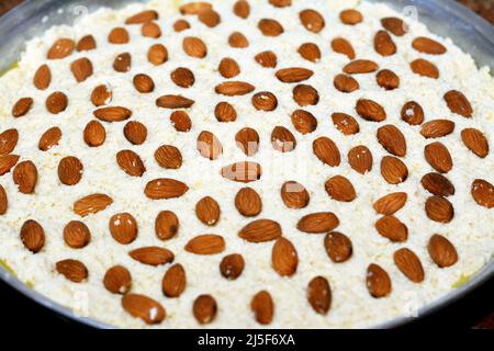Un vassoio di basbosa con mandorla pronta per essere cotta al forno, Basbuda è un dessert mediorientale che viene solitamente cotto nel mese del Ramadan, selettivo per fo Foto Stock