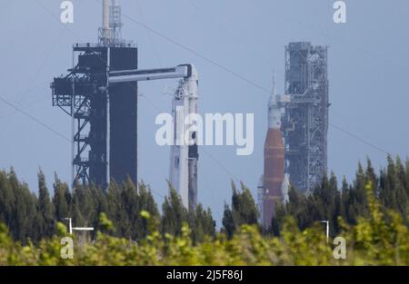 Florida, Stati Uniti. 22nd Apr 2022. Il razzo NASAs Space Launch System (SLS) con la navicella spaziale Orion a bordo è visto in cima a un lanciatore mobile al Launch Complex 39B, a destra, Come un razzo SpaceX Falcon 9 con la navicella spaziale Crew Dragon della società a bordo è visto sul trampolino di lancio al Launch Complex 39A mentre i preparativi per la missione Crew-4, venerdì 22 aprile 2022, presso il NASAs Kennedy Space Center in Florida. La missione di NASAs SpaceX Crew-4 è la quarta missione di rotazione dell'equipaggio della navicella spaziale SpaceX Crew Dragon e del razzo Falcon 9 verso la Stazione spaziale Internazionale come parte del agencys Commercial Cr Foto Stock