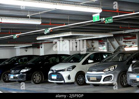 Cairo, Egitto, 14 2022 aprile: Auto parcheggiate all'interno di un parcheggio auto a più piani edificio, fuoco selettivo di auto moderne all'interno di un parcheggio chiuso gara Foto Stock