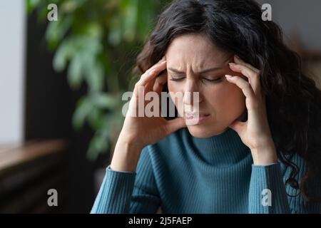 Disturbo d'ansia. Stressata giovane donna preoccupata con occhi chiusi che soffre di mal di testa o emicrania Foto Stock