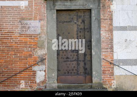 Antiche porte in legno massello con decorazioni intagliate a mano da artisti locali, nello splendido centro storico di Lucca Foto Stock