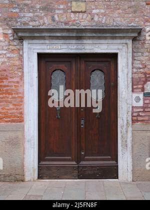 Porta di legno posta in un vicolo veneziano, Venezia, Italia. Foto Stock
