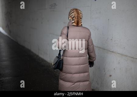 Le persone in città sono fuori in inverno. Passeggiate pedonali lungo il sentiero. Camminare attraverso l'area depressa. Tempo nuvoloso. Strade sgombrate per le persone. Foto Stock