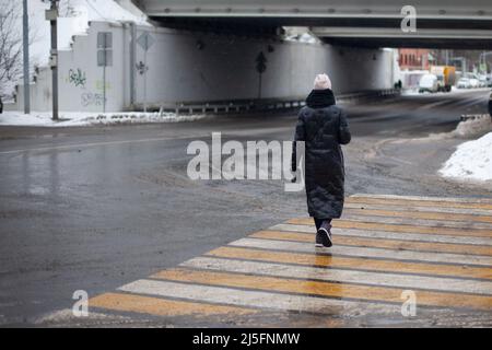 Le persone in città sono fuori in inverno. Passeggiate pedonali lungo il sentiero. Camminare attraverso l'area depressa. Tempo nuvoloso. Strade sgombrate per le persone. Foto Stock