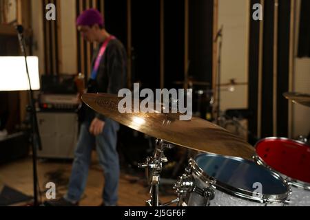 Primo piano con cappello e cembalo in studio. Kit tamburo Foto Stock