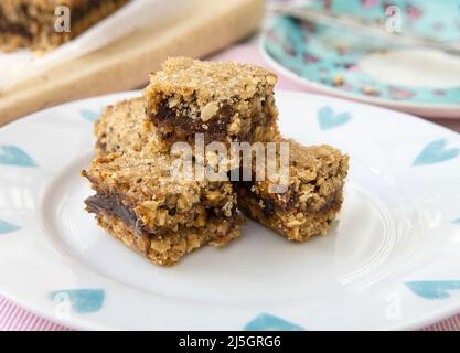 Vassoio preparato in casa cottura di fette Date e OAT. Tagliare in quadrati Foto Stock