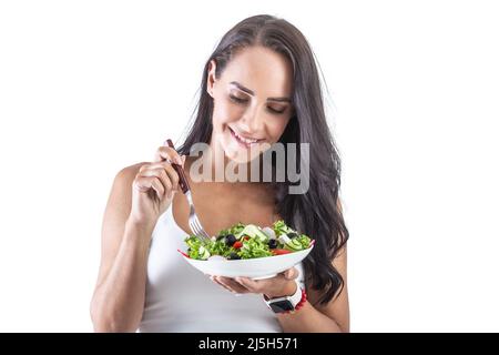 Bella donna che tiene una forchetta e mangiare sana insalata vegetariana. Isolato su bianco. Foto Stock