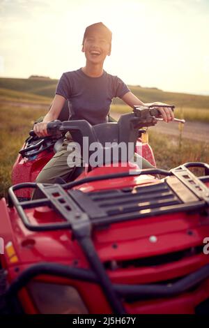 Donna che guida su quad rosso bike.quad bici sulle montagne Foto Stock