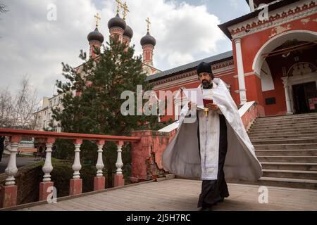 Mosca, Russia. 23rd aprile 2022. Un sacerdote ortodosso viene da un servizio alla vigilia della Pasqua ortodossa al monastero di Vysokopetrovsky a Mosca, in Russia. Si tratta del monastero stauropegion maschile della Chiesa ortodossa russa di Mosca, situato nel centro della città, a scendere verso il Cremlino in via Petrovka Foto Stock