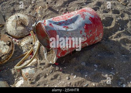 Barile arrugginito gettato sulla spiaggia, manichetta, spazzatura, inquinamento ambientale, ceneri in natura. Foto Stock