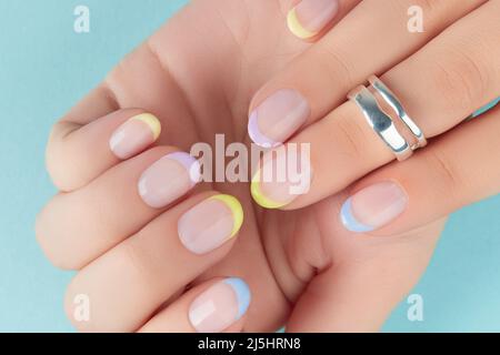 Primo piano mani donna curate su sfondo blu Foto Stock