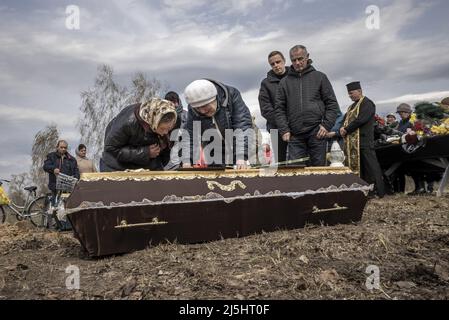 Borodyanka, Ucraina. 23rd Apr 2022. Amici e familiari partecipano ai funerali di Mark Bobrovytsky, 59, Halyna Bobrovytskyi, 59, e Maksym Bobrovytsky, 25 in un cimitero di Borodyanka, Ukriane morirono in appartamento a Borodyanka dopo uno sciopero aereo russo. Un'evacuazione pianificata di civili nella città meridionale assediata di Mariupol sabato è stata nuovamente ostacolata dall'esercito russo, secondo i leader ucraini. Foto di Ken Cedeno/UPI Credit: UPI/Alamy Live News Foto Stock