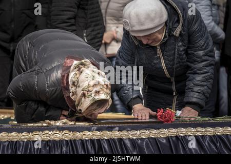 Borodyanka, Ucraina. 23rd Apr 2022. Amici e familiari partecipano ai funerali di Mark Bobrovytsky, 59, Halyna Bobrovytskyi, 59, e Maksym Bobrovytsky, 25 presso un cimitero di Borodyanka, Ukrianeon Sabato, 23 aprile 2022. Sono morti in appartamento a Borodyanka dopo uno sciopero aereo russo. Un'evacuazione pianificata di civili nella città meridionale assediata di Mariupol sabato è stata nuovamente ostacolata dall'esercito russo, secondo i leader ucraini. Foto di Ken Cedeno/UPI Credit: UPI/Alamy Live News Foto Stock