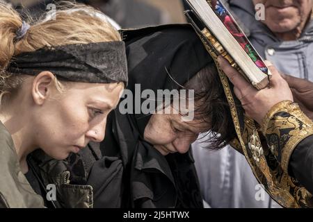 Borodyanka, Ucraina. 23rd Apr 2022. Amici e familiari partecipano ai funerali di Mark Bobrovytsky, 59, Halyna Bobrovytskyi, 59, e Maksym Bobrovytsky, 25 presso un cimitero di Borodyanka, Ukriane sabato 23 aprile 2022. Sono morti in appartamento a Borodyanka dopo uno sciopero aereo russo. Un'evacuazione pianificata di civili nella città meridionale assediata di Mariupol sabato è stata nuovamente ostacolata dall'esercito russo, secondo i leader ucraini. Foto di Ken Cedeno/UPI Credit: UPI/Alamy Live News Foto Stock