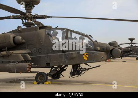 Da sinistra, esercito degli Stati Uniti 1st Lt. Sarah Dolitsky, AH-64E Apache Guardian attacco elicottero pilota e capo garanzia ufficiale 3 José García, ufficiale di manutenzione dell'aviazione, assegnato a 7th Squadron, 17th Cavalry Regiment, 1st Air Cavalry Brigade, 1st Cavalry Division effettua un'ispezione preflight su AH-64E Apache Guardian Attack Helicopter prima di completare la qualifica di tabella IV e di tabella V durante il gunnery Apache a Mirosławiec, Polonia, 13 aprile 2022. La Divisione Cavalleria del 1st è tra le altre unità assegnate al V corpo, il corpo americano dispiegato in Europa che lavora a fianco degli alleati della NATO e delle regi Foto Stock