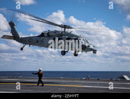 220419-N-SY758-1066 OCEANO ATLANTICO (19 aprile 2022) Capt. Robert Aguilar, comandante della USS George H.W. Bush (CVN 77), pilota un MH-60s Sea Hawk elicottero, attaccato a Helicopter Sea Combat Squadron (HSC) 7, durante il suo volo finale prima del pensionamento, 19 aprile 2022. George H.W. Bush fornisce all'autorità di comando nazionale capacità di lotta contro la guerra flessibile e personalizzabile attraverso il gruppo di sciopero del vettore che mantiene la stabilità e la sicurezza marittima al fine di garantire l'accesso, scoraggiare l'aggressione e difendere gli interessi degli Stati Uniti, alleati e partner. (STATI UNITI Foto Navy di Mass Communication Specialist 3 Foto Stock