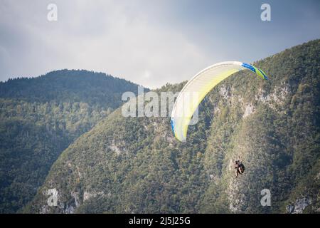 Foto di parapendio volare in aria con un'ala bianca. Il parapendio è lo sport di avventura ricreativo e competitivo dei parapendio volanti: Ligh Foto Stock