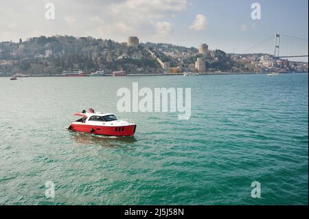 Tour in barca rossa a Bosforo sullo sfondo del paesaggio urbano di Istanbul Foto Stock