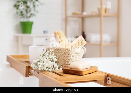 Vassoio da bagno con diversi accessori e fiori di gypsophila in bagno Foto Stock