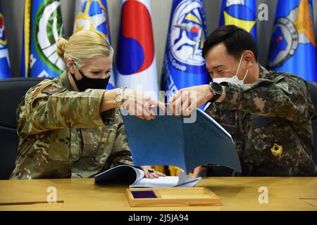 Osan Air base, Corea del Sud. 8th Apr 2022. Jonelle Eychner, comandante del gruppo di supporto alla Missione 51st, e il Colon. Soon Tae Kim, comandante del gruppo di supporto e servizio operativo dell'Aeronautica militare della Repubblica di Corea (ROK), scambia opuscoli firmati durante una cerimonia del Memorandum of Understanding sulla base aerea di Osan, ROK, 6 aprile 2022. Il MOU è stato firmato l'ultima volta nel 2016 e comprende solo circa 3-4 pagine di procedure. Ora ha oltre 50 pagine che coprono tutto, dalle condizioni di protezione della forza, al controllo di qualità fino all'aggiunta di misure di sicurezza COVID-19. (Credit Image: © U.S. Air Force/ZUMA Press Wire Service Foto Stock