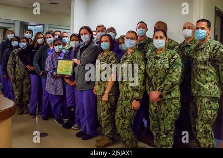 San Diego, Stati Uniti. 13th Apr 2022. Il comando NMRTC (Navy Medicine Readiness and Training Command) il personale dell'unità di cura intensiva di San Diego e il comando dirigente pongono per una foto durante la cerimonia del DAISY Award for Extraordinary Nurses in ospedale il 13 aprile. Il DAISY Award è stato assegnato al personale dell'unità di terapia intensiva di NMRTC San Diego per esprimere gratitudine e riconoscere gli operatori sanitari che hanno creato ambienti che hanno favorito l'assistenza, la fiducia, il rispetto reciproco e lo sviluppo professionale continuo, combattendo al contempo la pandemia COVID-19. La missione di NMCSD è preparare i membri del servizio a distribuirlo a supporto di Foto Stock