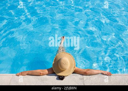 vista dall'alto della donna in cappello di paglia rilassante in piscina Foto Stock