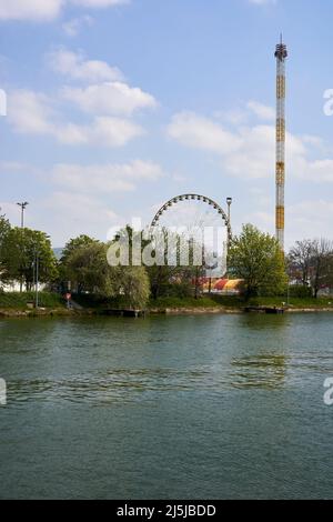 Stoccarda, Germania - 22 aprile 2022: Festa primaverile (Frühlingsfest) con giostre divertenti. Ruota panoramica e torre a caduta libera presso il fiume a mezzogiorno. Germania, Foto Stock