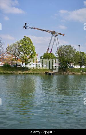 Stoccarda, Germania - 22 aprile 2022: Festa primaverile (Frühlingsfest) con giostre divertenti. Oscillazione a sfioro vicino al fiume a mezzogiorno. Germania, Stoccarda, Wasen. Foto Stock