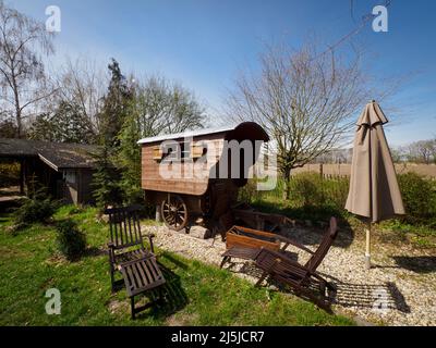 Kienitz, Germania. 12th Apr 2022. La storica carrozza del pastore 'chäfers Ruh' si trova sul terreno del 'Erlenhof'. La fattoria di vacanze di Barbara Brunat nel Medio Oderbruch offre da aprile a ottobre vicino-a-natura vacanze su una zona spaziosa e pernottamento in sei carrozze pastorelli e in una cabina di legno. Un massimo di 15 ospiti possono trovare un posto dove dormire in azienda, e non ci sono né TV né radio nei vagoni e nella cabina. (A dpa: ' 'chäferstündchen im Schäferwagen' im Oderbruch') Credit: Soeren Stache/dpa/Alamy Live News Foto Stock