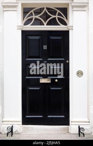 La famosa porta nera al numero 11 Downing Street, tradizionalmente la casa del Cancelliere dello scacchiere, Westminster, Londra, Regno Unito Foto Stock