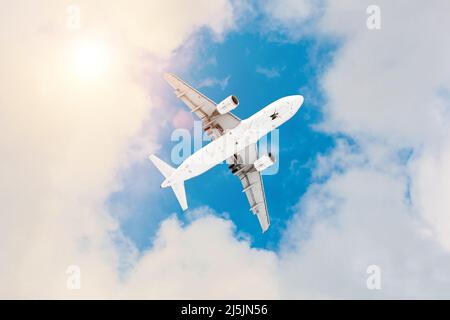 Aereo commerciale che vola sopra le nuvole in luce solare divina Foto Stock