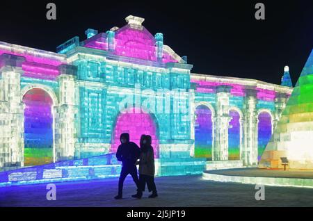 I turisti si godono le sculture di ghiaccio colorate in Harbin International Ice and Snow Sculpture Festival (Ice & Snow World) Foto Stock