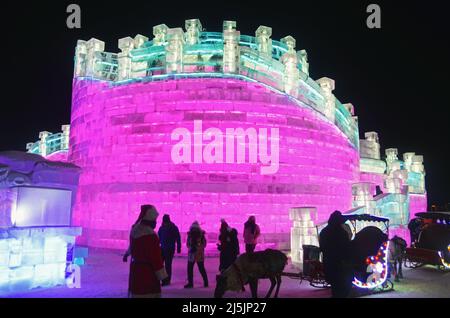 I turisti si godono le sculture di ghiaccio colorate in Harbin International Ice and Snow Sculpture Festival (Ice & Snow World) Foto Stock