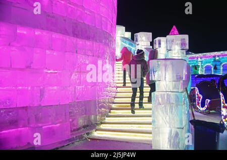 I turisti si godono le sculture di ghiaccio colorate in Harbin International Ice and Snow Sculpture Festival (Ice & Snow World) Foto Stock