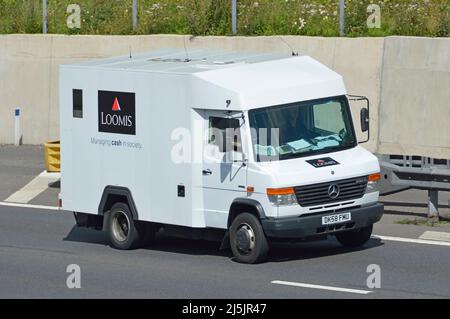 Vista laterale e frontale del logo bianco Loomis Cash & Valuables Transport business Company sul camion blindato ad alta sicurezza che guida sull'autostrada del Regno Unito Foto Stock