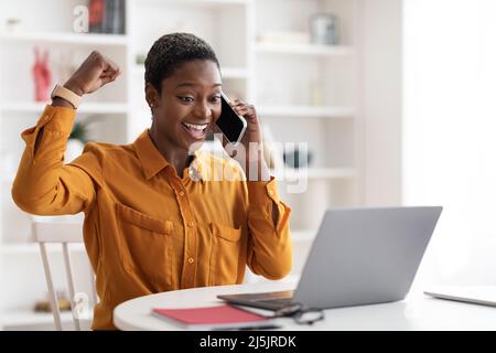 Imprenditore emotivo femminile che lavora online, parlando sul telefono cellulare Foto Stock