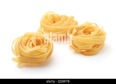 Tre nidi di pasta a nastro di tagliatelle non cotti isolati sul quale Foto Stock