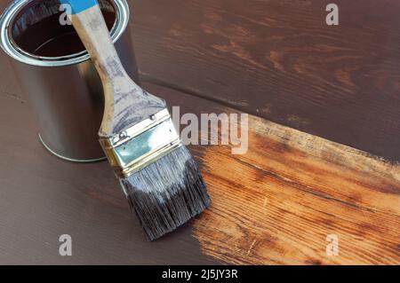 Pennello e latta di vernice su superficie di legno Foto Stock