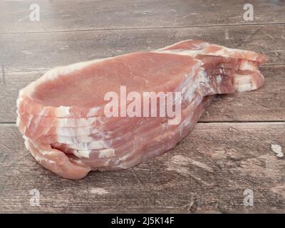 Fettine di pancetta grezza su un tavolo di legno Foto Stock