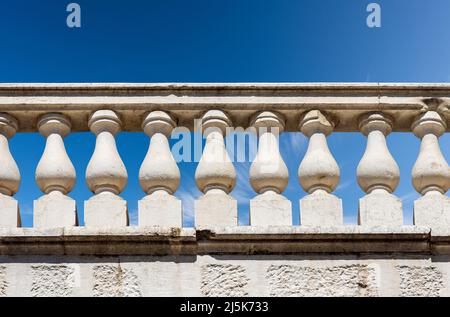 Primo piano di una balaustra in marmo bianco in stile classico contro un cielo blu chiaro e spazio copia. Brescia centro, Lombardia, Italia, Europa. Foto Stock
