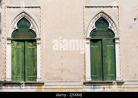 Primo piano di due antiche finestre con arco in stile gotico veneziano, piccola città di Oderzo, provincia di Treviso, Veneto, Italia, Europa. Foto Stock