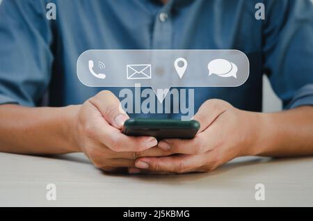 Uomo d'affari che tiene uno smartphone utilizzando le informazioni di contatto e parlare. Concetto di comunicazione aziendale. Foto Stock
