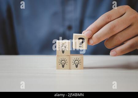 Mettere mano cubi di legno con punto interrogativo simbolo sul tavolo e copiare space.Business concetti. Foto Stock