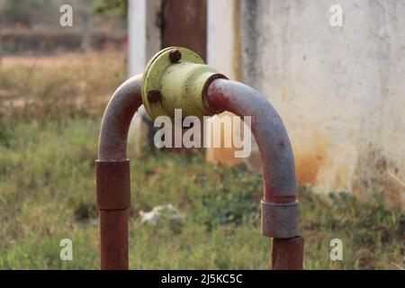 Vecchio motore borewell e sistema di pompaggio con tubazioni zincate per l'uscita dell'acqua con valvola di non ritorno progettata per l'irrigazione Foto Stock