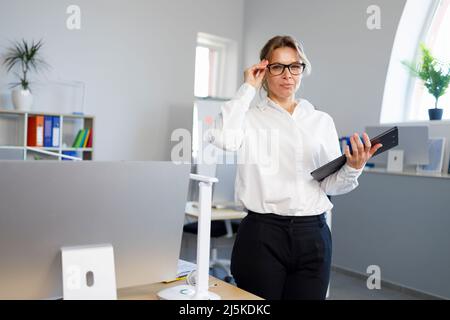 Attraente donna di affari matura in ufficio Foto Stock