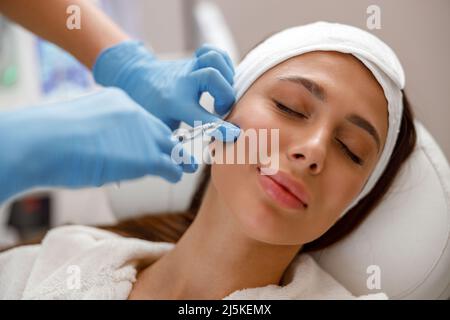 Donna che ottiene l'iniezione in faccia alla clinica di chirurgia plastica Foto Stock