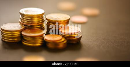 Monete in euro impilate sul primo piano del tavolo Foto Stock