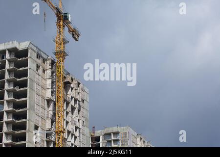 Costruzione di edifici a più piani. Moderno edificio a più piani. Case con struttura in cemento armato. Gru da cantiere. Foto Stock